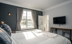 a bedroom with a white bed and a television at Sutton Vale in Deal