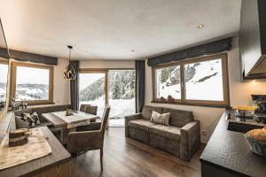 a living room with a couch and a table at Aurela Mountain Chalets in Selva di Val Gardena