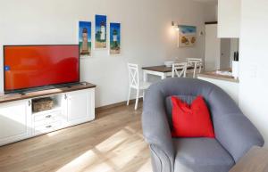 a living room with a grey chair with a red pillow at Baabe Inselparadies Fewo Bernstein in Baabe