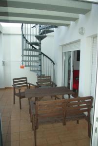 una mesa y bancos en una habitación con escalera en Apartamento Mirador de Conil, en Conil de la Frontera