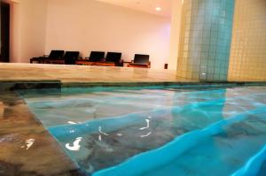 ein Wasserbecken in einem Raum mit Stühlen in der Unterkunft Evora Olive Hotel in Évora