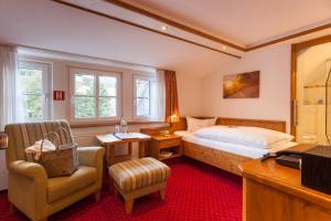 a bedroom with a bed and a desk and a chair at Landhotel Voss im TalVital in Saalhausen +90 photos