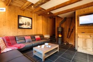 uma sala de estar com um sofá e uma televisão em Chalet l'écureuil em Méribel