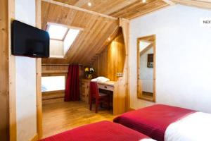 ein Schlafzimmer mit einem Bett und einem Schreibtisch in einem Zimmer in der Unterkunft Chalet l'écureuil in Méribel