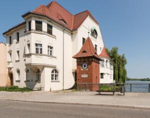 a building with a clock tower next to a street at Fewo auf der Dominsel - SEEROSE in Brandenburg an der Havel