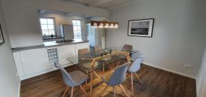 Un comedor con una mesa de cristal y sillas. en Ferienhaus Südwesthörn, en Emmelsbüll-Horsbüll