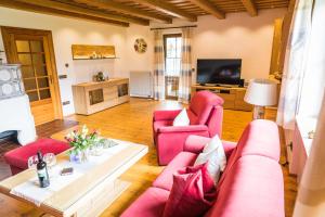 uma sala de estar com mobiliário rosa e uma televisão em Ferienhaus Eva em Ruhpolding