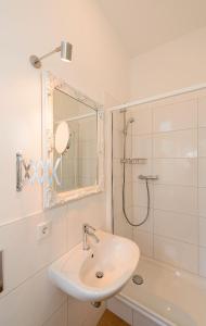 a white bathroom with a sink and a shower at Fewo auf der Dominsel - SEEROSE in Brandenburg an der Havel +8 photos