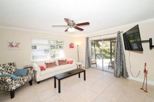 uma sala de estar com um sofá branco e uma ventoinha de tecto em Pet-Friendly, King Bed, Close to Siesta Beach, Restaurants, Shopping em Sarasota