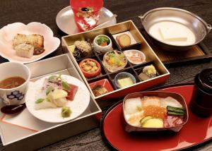 京都市にあるサンメンバーズ京都嵯峨の食べ物のトレイが並ぶテーブル