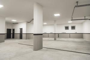 a large empty room with white walls and columns at Aurela Mountain Chalets in Selva di Val Gardena