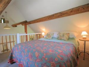 a bedroom with a bed with a colorful blanket at Mayfly Cottage in Quenington