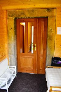 Habitación con puerta de madera y banco blanco en Chalupa Ádr u Duchků en Teplice nad Metují