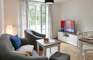 a living room with a couch and a tv at Baabe Inselparadies Fewo Jasmund R in Baabe
