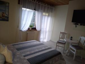 1 dormitorio con 1 cama y una ventana con cortinas en Jarek en Pobierowo