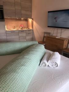 ein Schlafzimmer mit einem Bett mit zwei Handtüchern und einem Waschbecken in der Unterkunft La Prada in Laax