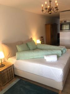 1 dormitorio con 1 cama blanca grande con almohadas verdes en La Prada, en Laax
