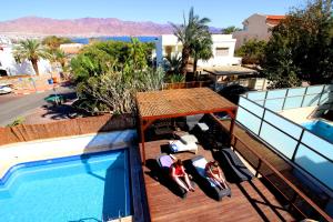 a balcony with a swimming pool next to a resort at Custo Club in Eilat