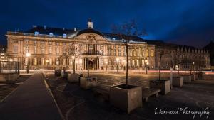 a large building with trees in front of it at night at Studio des jardins suspendus in Liège +28 photos