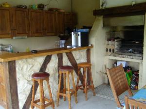 a kitchen with a counter with stools and an oven at GITE MASKALI in Thenon