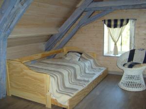 een bed in een houten kamer met een raam bij GITE MASKALI in Thenon