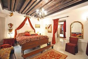 a bedroom with a bed and a mirror and a chair at Zattere Cottage close to Guggenheim in Venice