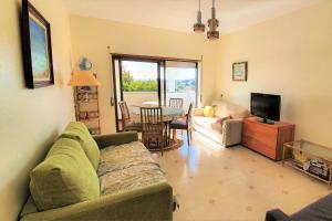 a living room with a couch and a table with a television at LovelyStay - The Algarvean Oasis in Armação de Pêra