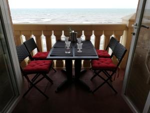 - une table avec quatre chaises et une vue sur l'océan dans l'établissement IDEALLY located on BEACH, à Port Saplaya