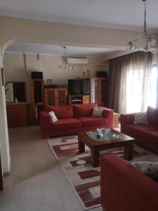 a living room with red couches and a coffee table at Comfortable Apartment in Kato Toumpa in Thessaloniki