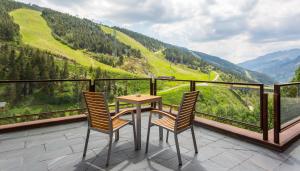 a table and two chairs on a balcony with a view at Sport Hotel Hermitage & Spa in Soldeu