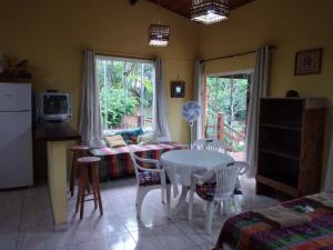 cocina y comedor con mesa y sillas en Casa da Nana - Búzios, en Búzios