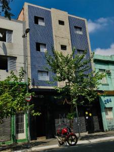 una motocicleta roja estacionada frente a un edificio en Hotel Gasometro, en São Paulo