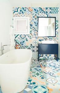 a bathroom with a tub and a sink and a mirror at CalaLanzarote Suites Hotel - Adults Only in Playa Blanca