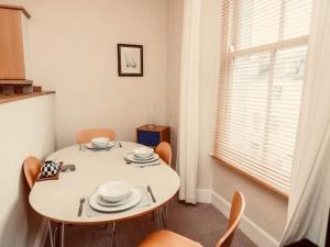 une salle à manger avec une table et des chaises blanches dans l'établissement Durnford St- Amazing location - free WiFi, à Plymouth