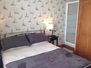 - une chambre avec un lit et du papier peint avec des voiliers dans l'établissement Durnford St- Amazing location - free WiFi, à Plymouth
