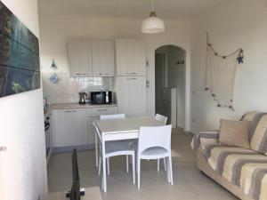 cocina y sala de estar con mesa y sillas. en Casa Moro, en Trinità dʼAgultu