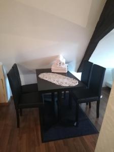ein schwarzer Tisch und Stühle mit einer Serviette drauf in der Unterkunft Weingut und Gästehaus Vongerichten in Oberhausen