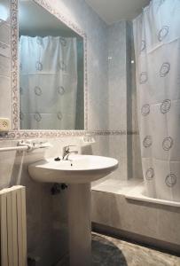 ein Bad mit einem Waschbecken, einem Spiegel und einer Dusche in der Unterkunft Hotel Florida Mar in Sanxenxo