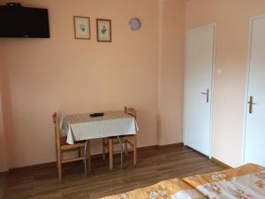 a dining room with a table and chairs and a tv at Margitapartman in Bük