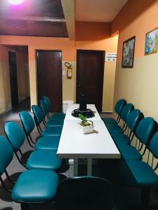 a conference room with a table and blue chairs at Hotel Gasometro in São Paulo