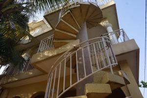 a building with spiral stairs in front of a palm tree at Ramaya Auberge Espagnole in Grand-Popo