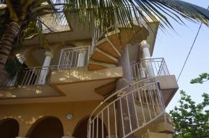 a yellow building with stairs and a palm tree at Ramaya Auberge Espagnole in Grand-Popo