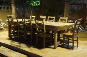 una mesa de madera con sillas alrededor en un patio en Ramaya Auberge Espagnole, en Grand-Popo