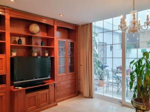 een woonkamer met een tv en een groot raam bij Triana Luxury Home in Sevilla