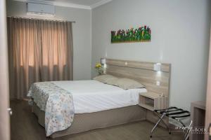 ein Schlafzimmer mit einem großen Bett in einem Zimmer in der Unterkunft Hotel De Klomp in Carambeí