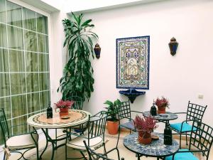 a patio with two tables and chairs and plants at Triana Luxury Home in Seville