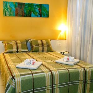 a hotel room with two beds with towels on them at Hotel Pampulha Palace in Belo Horizonte