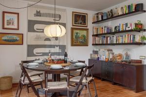 a dining room with a table and chairs and bookshelves at Sa Graonada in Calella de Palafrugell