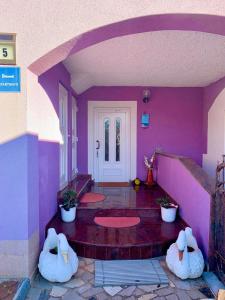 two stuffed animals sitting in a room with a purple wall at Villa Lory Krk in Krk