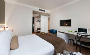 um quarto com uma cama e uma secretária com um computador em Píer Vitória Hotel em Vitória